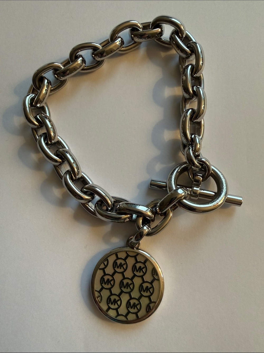 Michael Kors Silver-tone Toggle Bracelet with Dual Sided Logo Charm.